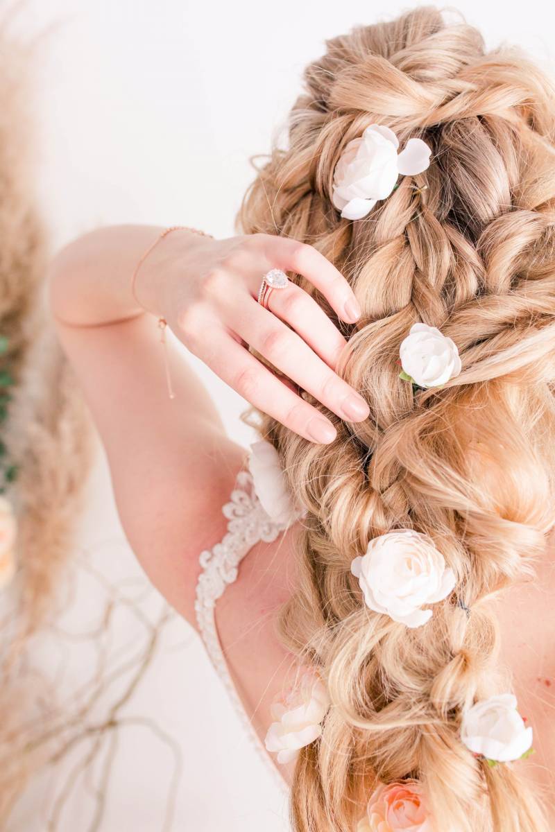 Bride with white floral accents in braided hair 
