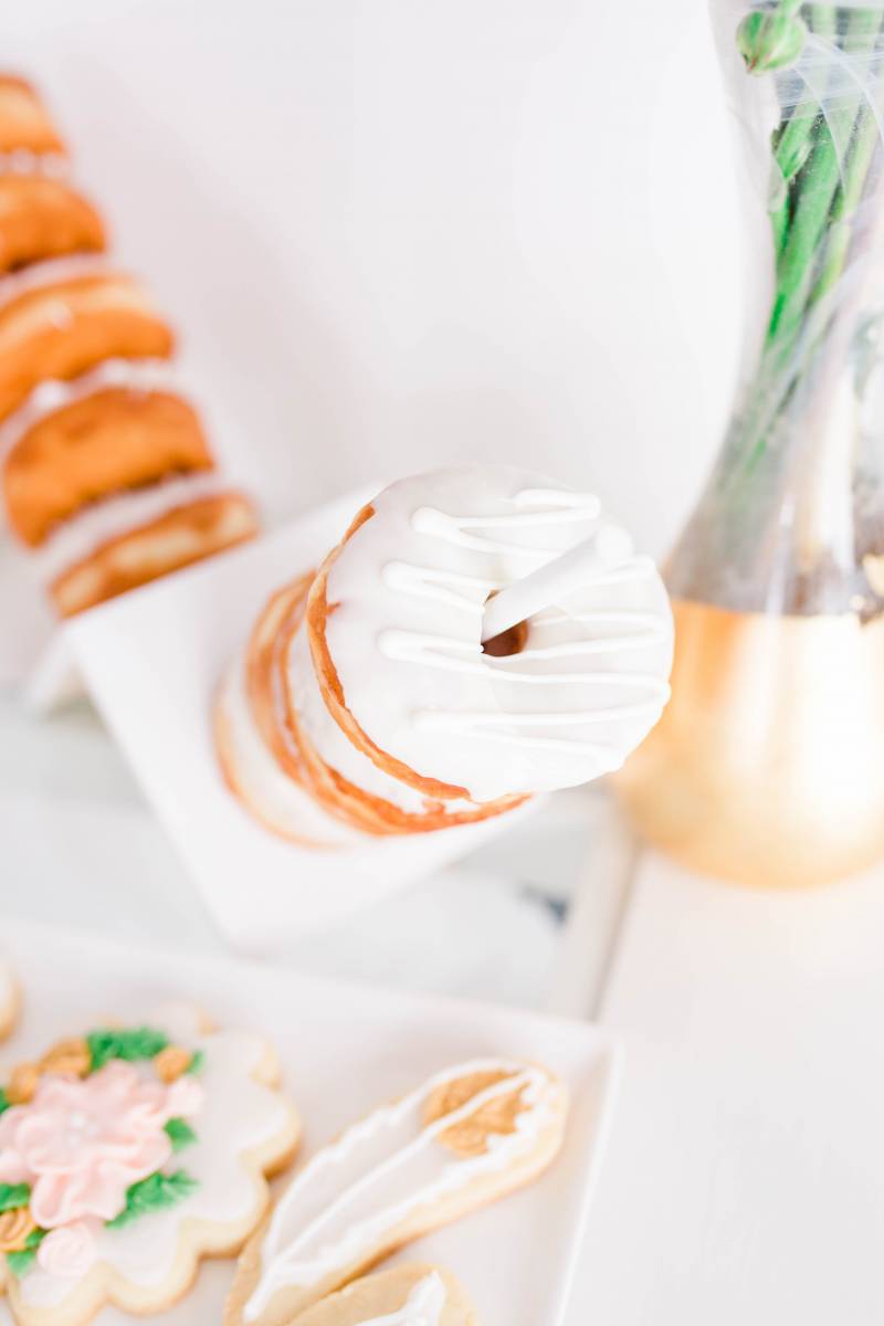 white doughnuts on stick beside floral arrangement 