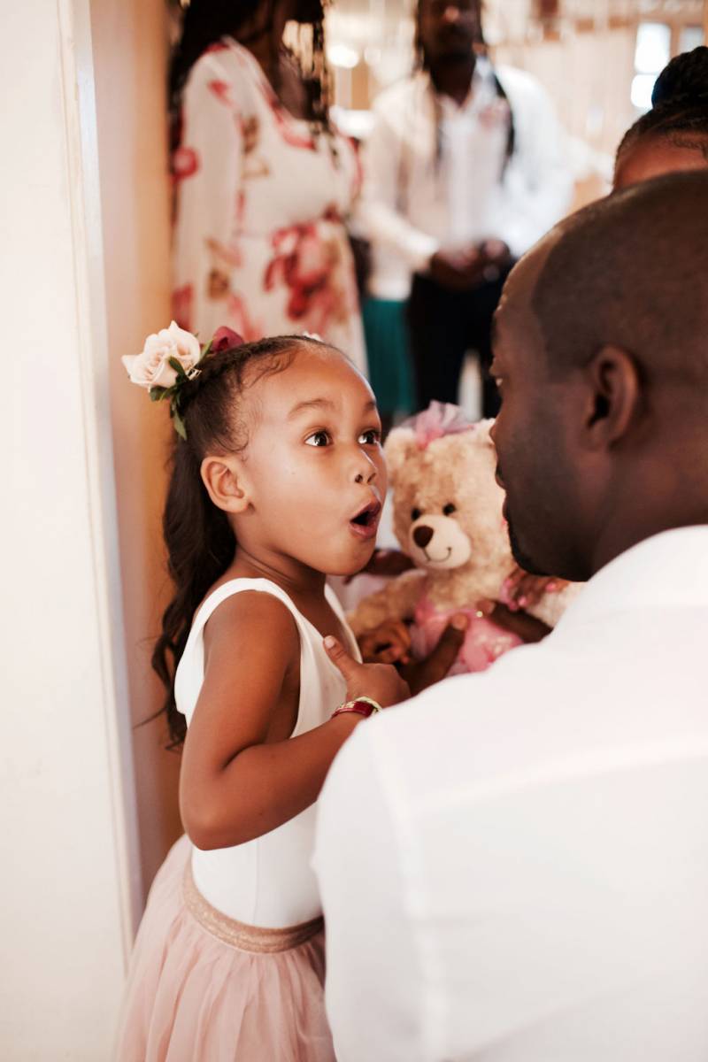 Flower girl expressive face looking at man in white shirt