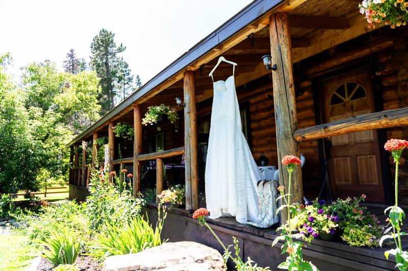 White dress hanging from wooden cabin eavestrough 