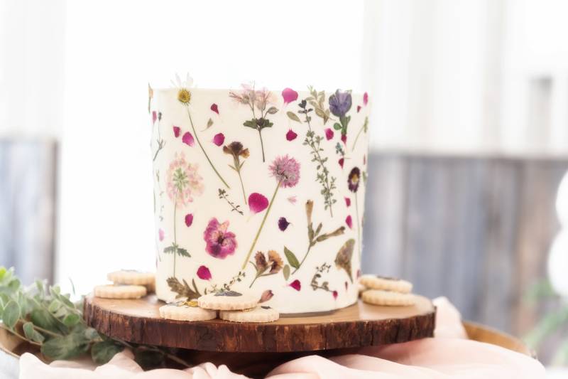 Floral printed wedding cake displayed on wooden platter