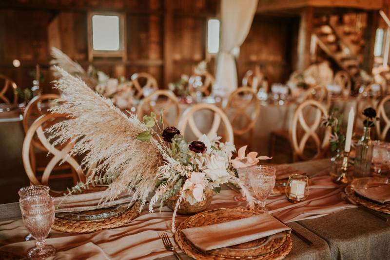 Large white grass centerpiece on table with long blush table runner 