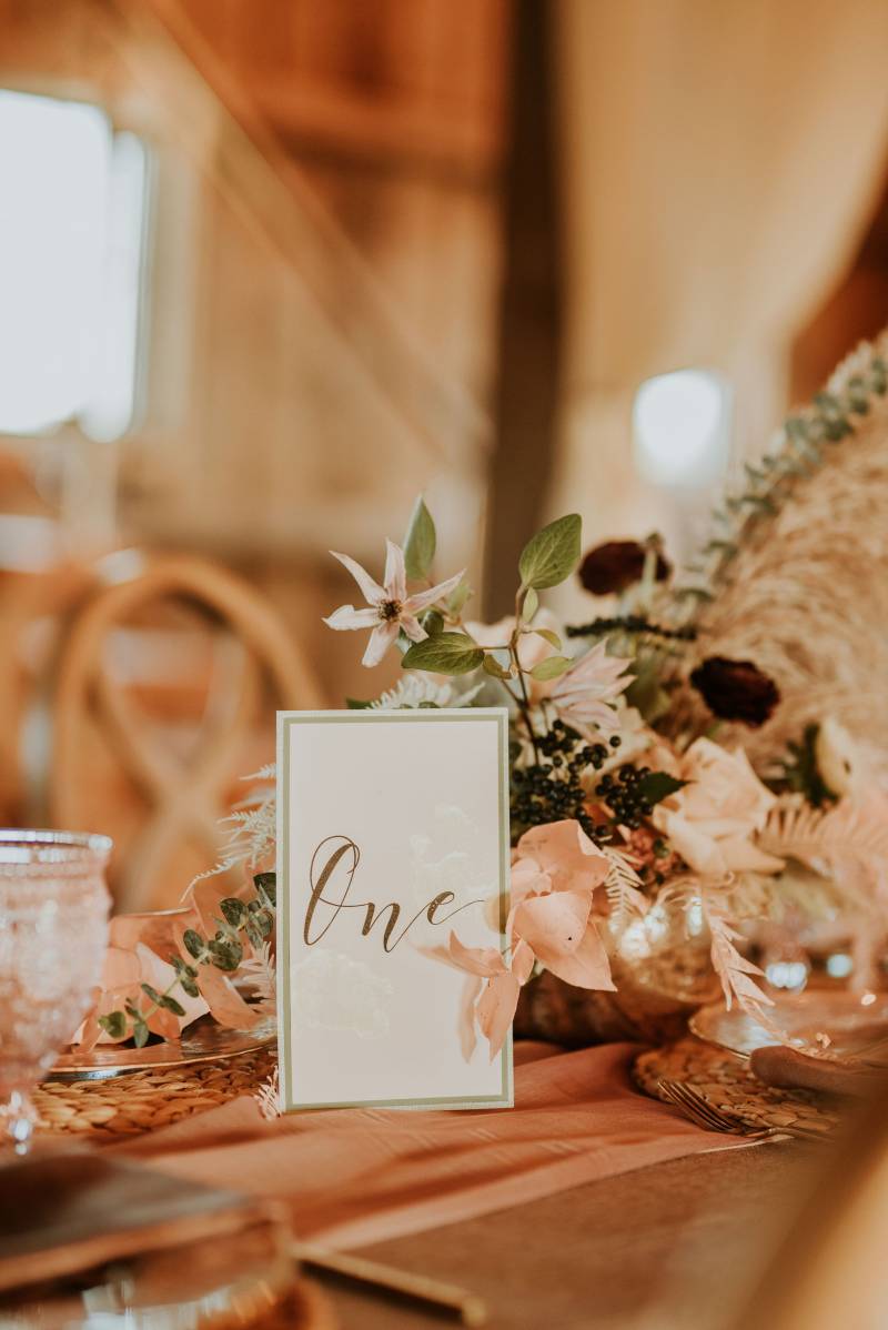 Table number in front of blush floral centerpiece 
