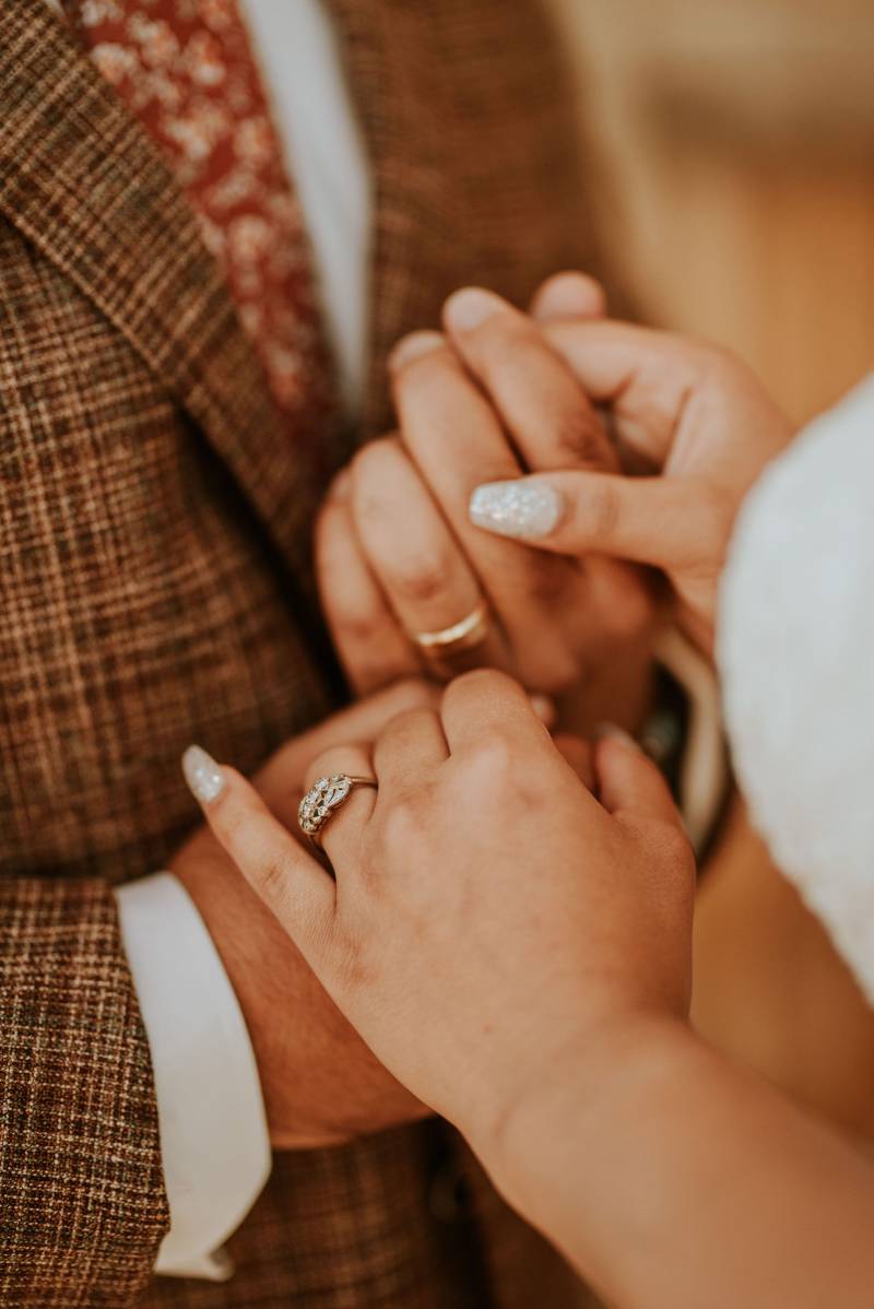Bride and grooms hands showing wedding ring 