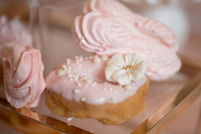 Pink macaroons beside pink frosted mini doughnut