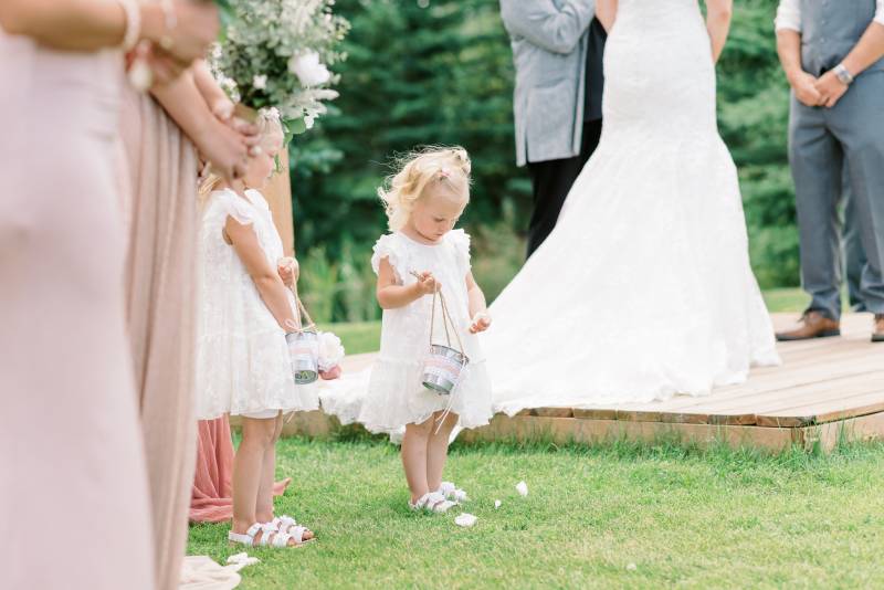 Two Flower girls stand with silver buckets beside bride and groom 