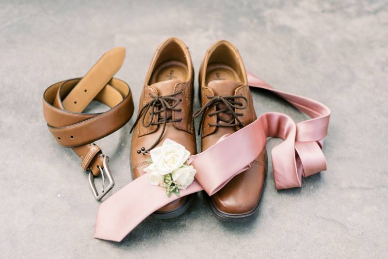 Brown belt and dress shoes with blush tie and white boutonniere 